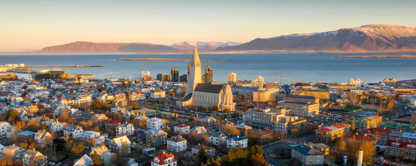 Blick über Reykjavík mit Hallgrímskirkja und der Bucht im Abendlicht