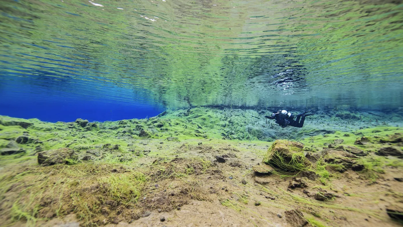 Taucher im klaren Wasser der Silfra-Spalte